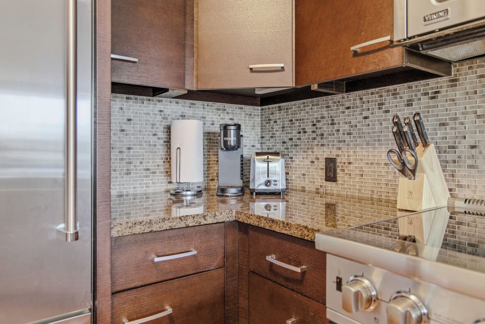 Detailed view of the polished granite countertops and custom mosaic tile backsplash.