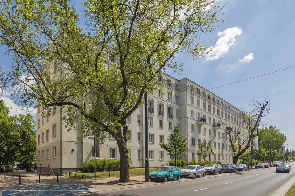 Exterior view of the apartment building surrounded by green trees.