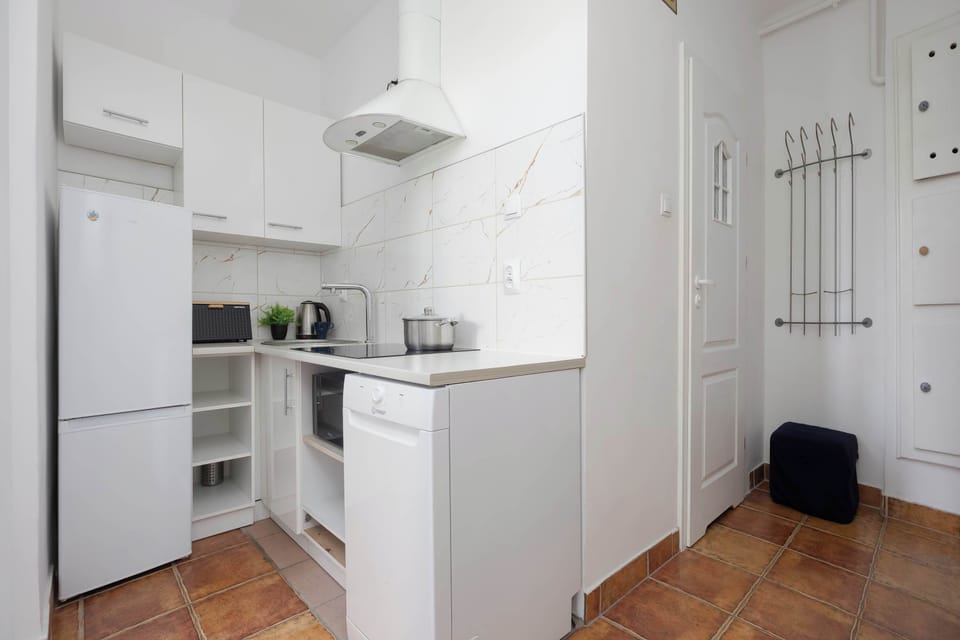 Compact kitchen featuring white cabinets and modern appliances.