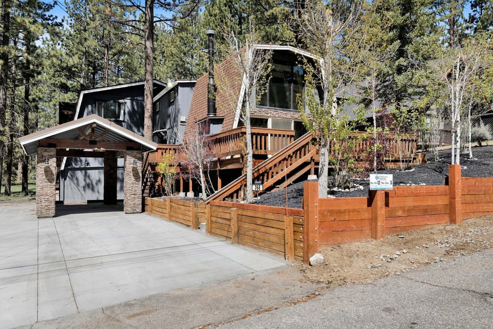 Welcoming cabin entry surrounded by towering pine trees, offering fresh mountain air and a peaceful forest setting, the perfect first impression for your Big Bear Lake getaway.