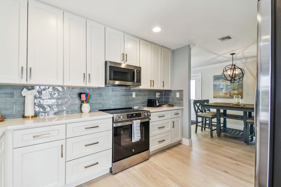 Kitchen with stainless stove and blue tile backsplash