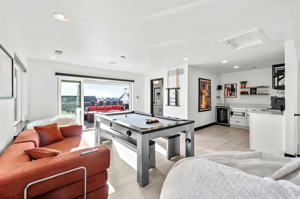 Game room with 100" Smart TV, pool table, Nintendo Switch, and wet bar.