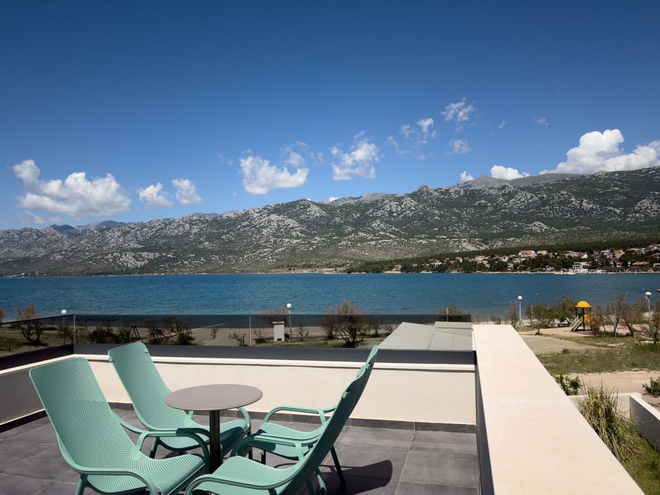 Private balcony with seating area and wide views of the sea, bay and Velebit.