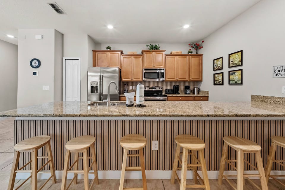 This stylish kitchen, with rich wooden cabinets and a spacious granite island, is perfect for casual dining or coffee. Its warm tones and contemporary decor create a welcoming space for culinary adventures and gatherings.