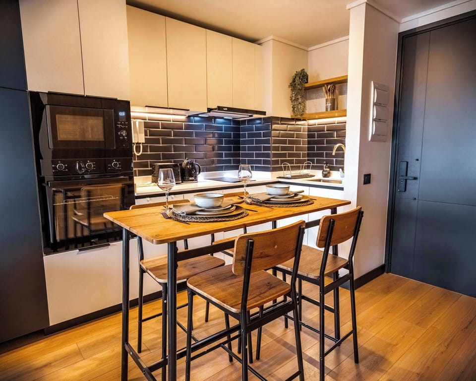 Modern kitchen with sleek design and cozy dining area, perfect for intimate meals.