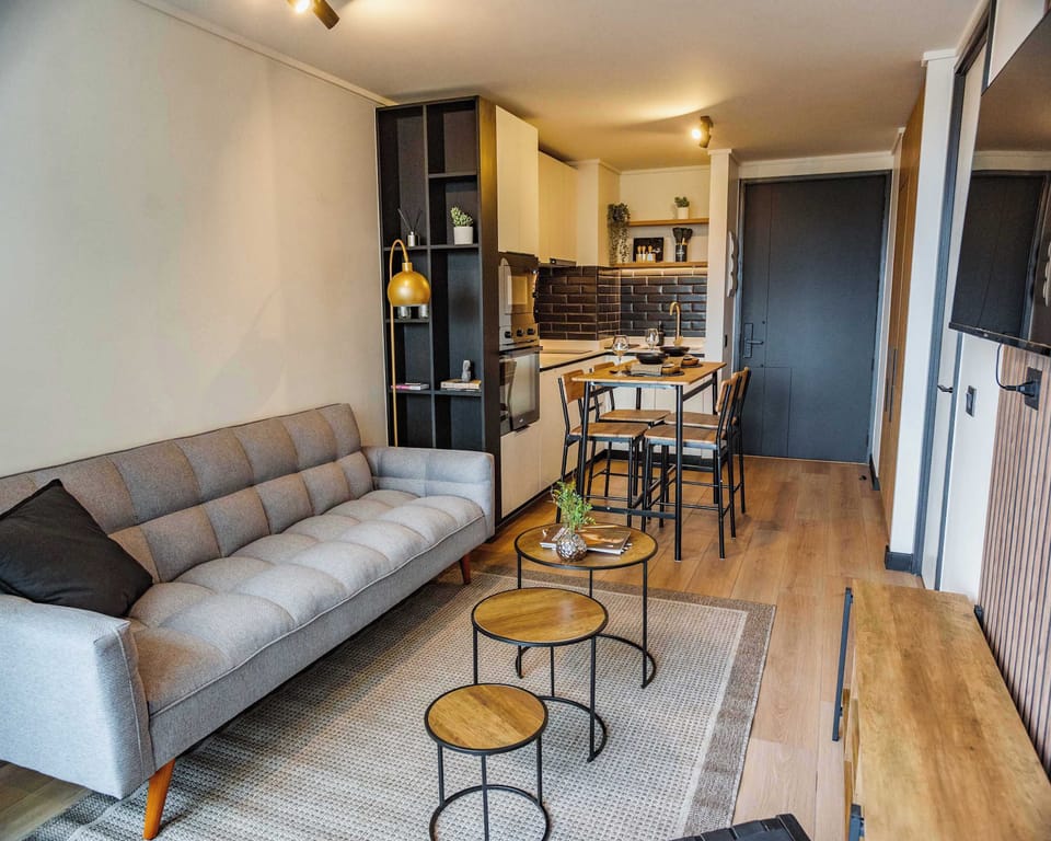 Cozy and modern living area with stylish decor and a fully equipped kitchen, perfect for a relaxing stay in the heart of the city.