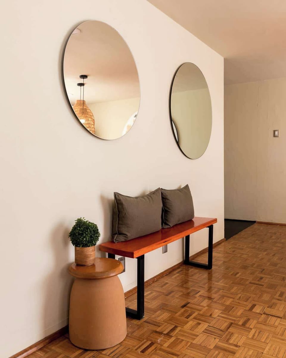 Minimalist entry nook with modern details and functional seating, ideal for getting ready before heading out to explore the city or comfortably settling in after your arrival.