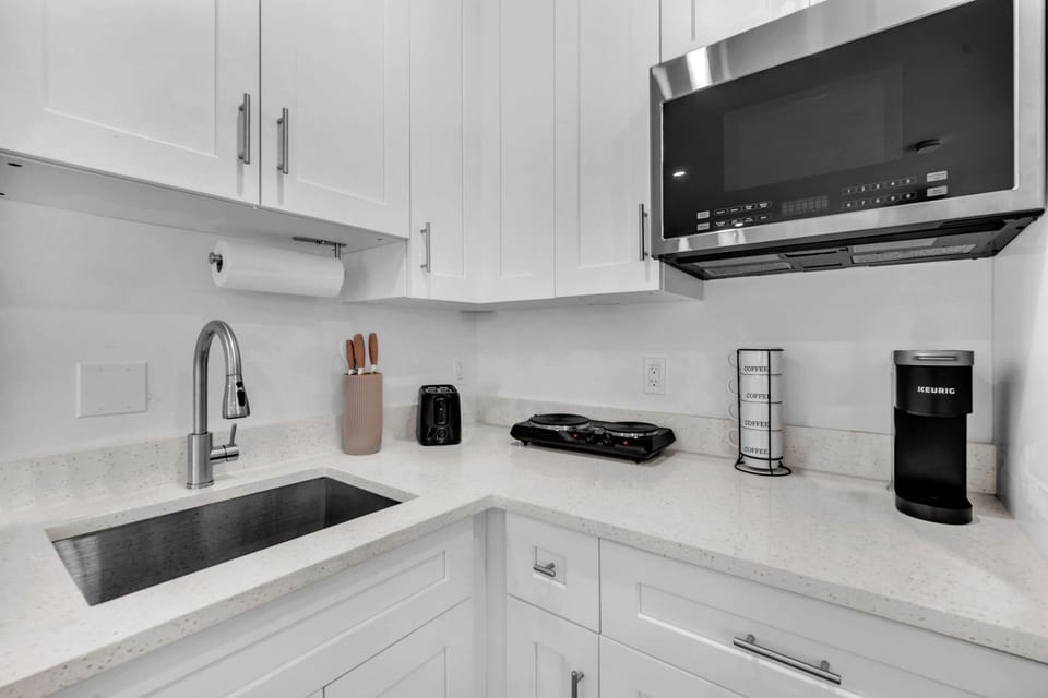 The kitchenette fully stocked with silverware, plates, and essential cookware, making it easy to prepare and enjoy meals during your stay.