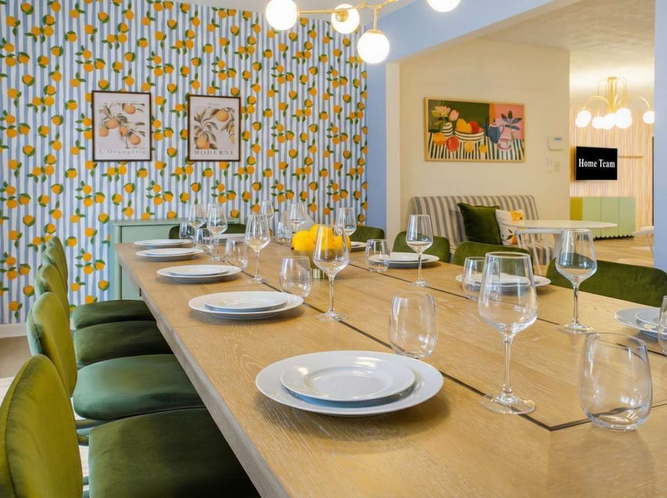Dinner is served! Gather the whole group around this expansive wooden dining table. With seating for everyone, a playful lemon-themed accent wall, and elegant glassware ready, it's the perfect spot for unforgettable vacation feasts