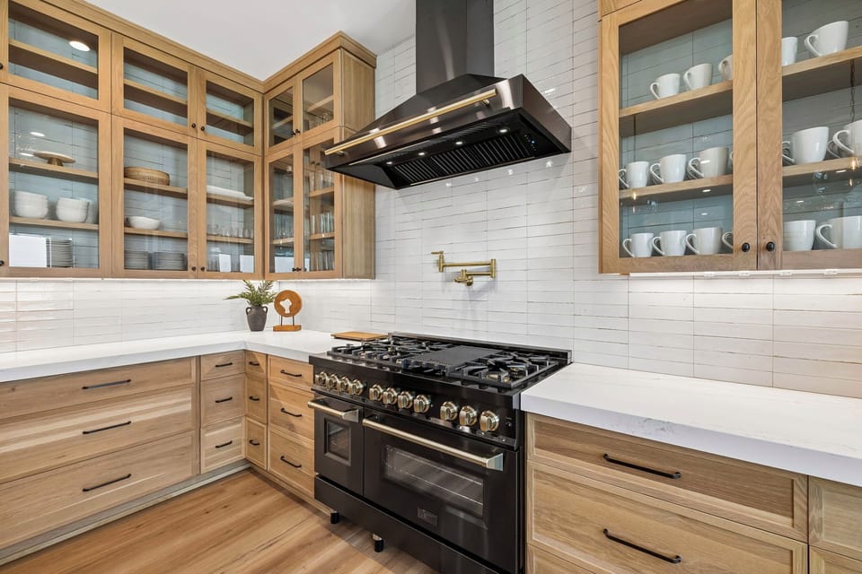 Your fully equipped kitchen features gleaming appliances, warm wood cabinetry, and pristine marble countertops—perfect for crafting gourmet meals or enjoying morning coffee together.