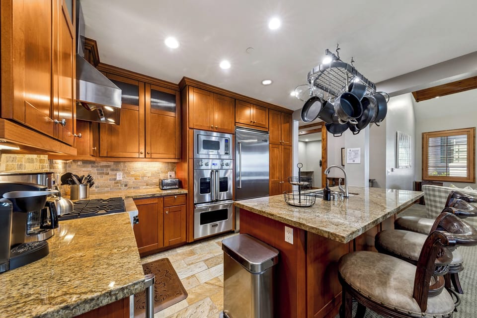 Step into your culinary oasis with rich wood cabinetry, gleaming granite counters, and top-tier stainless appliances. The spacious island invites you to gather, cook, and create lasting memories together.