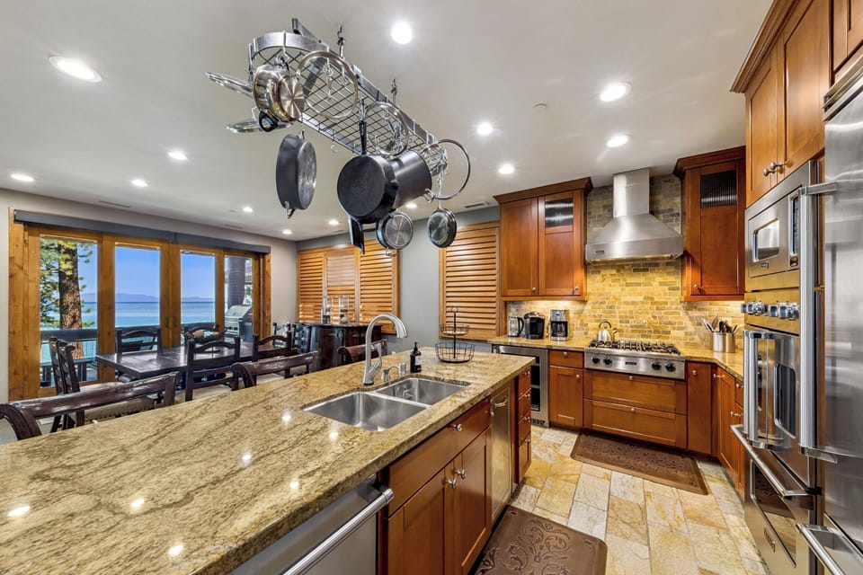 Gather in your gourmet kitchen with gleaming granite counters, professional-grade appliances, and breathtaking lake views through expansive windows—perfect for cooking and entertaining together.