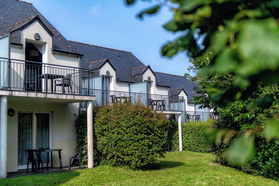 Breton-style apartment blocks with private balconies, set among the trees of the private park surrounding the residence.