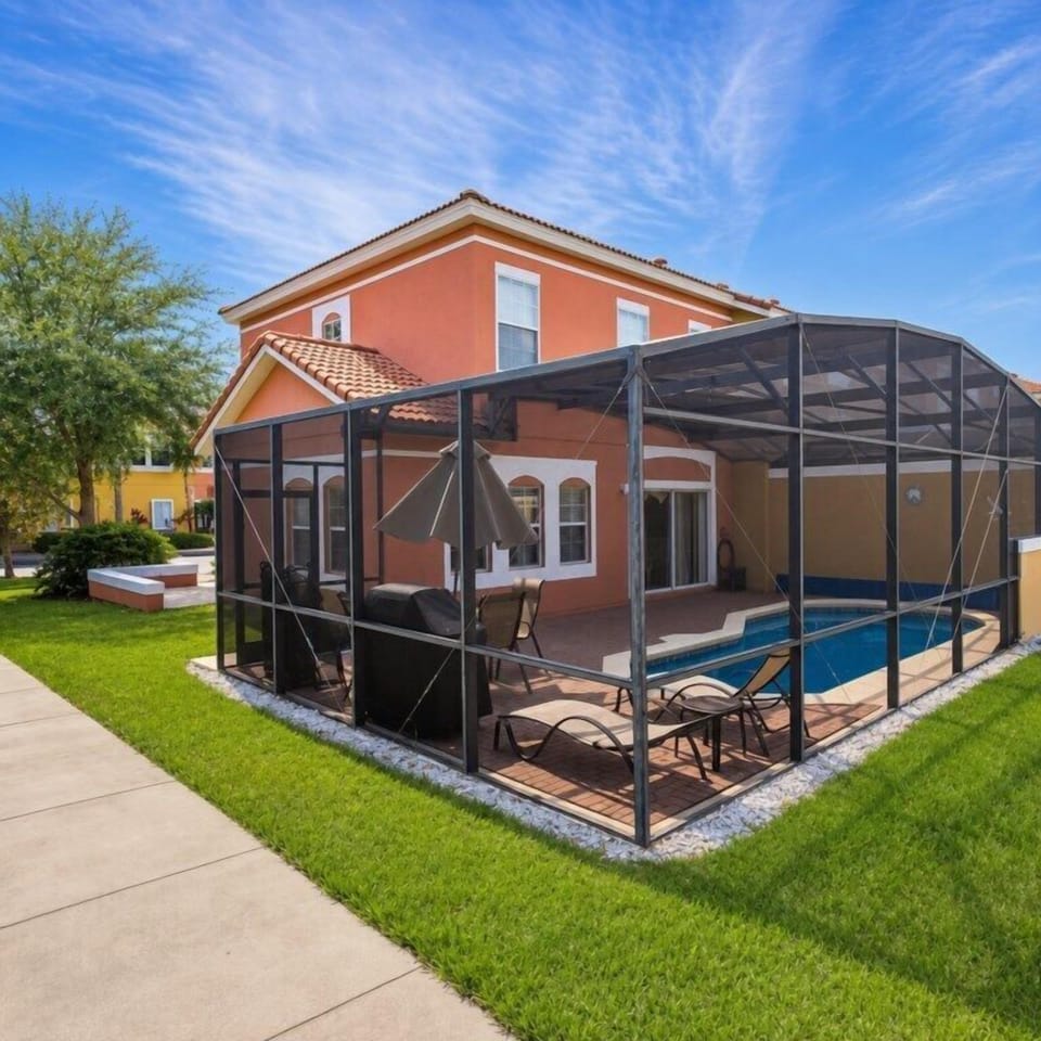 Relax in the private screened pool area with sun loungers and patio seating.