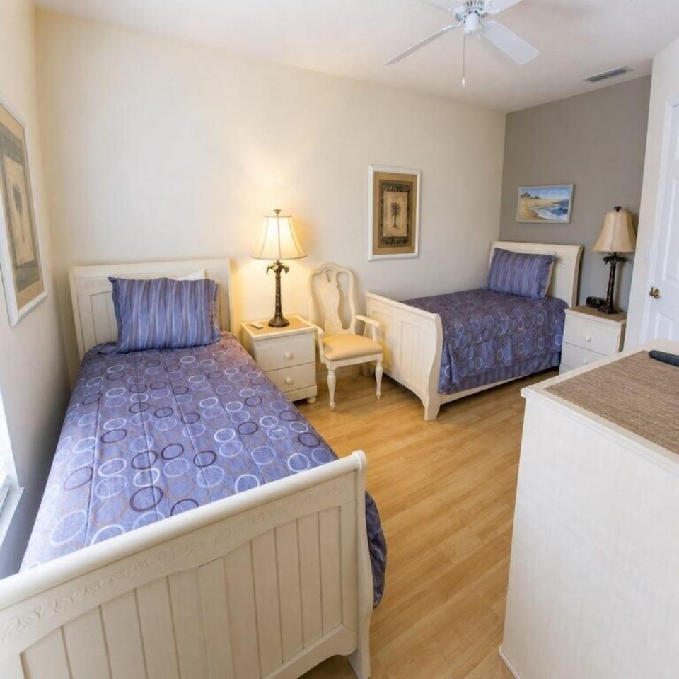 Charming twin bedroom with cozy bedding and warm lighting.