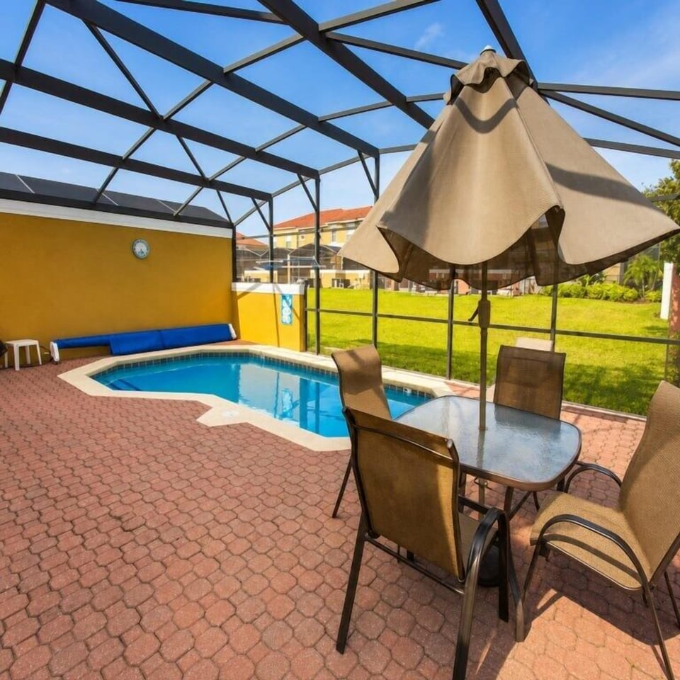 Private screened pool with patio seating, perfect for relaxing in the sun.