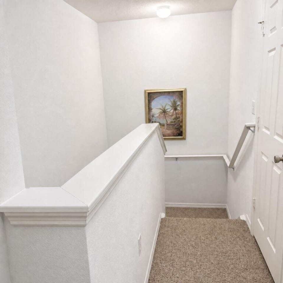 Bright stairway with a tropical painting and soft carpeted steps.
