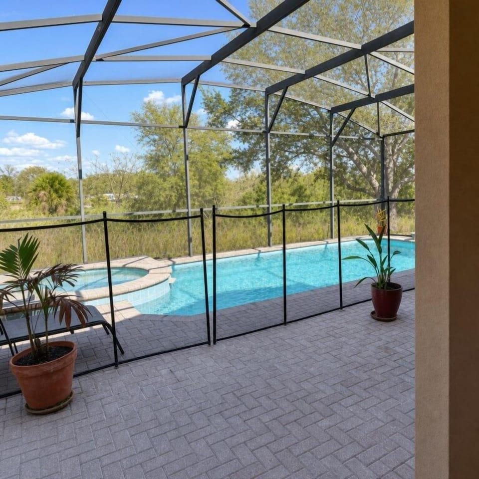 Private screened pool area with lush views, perfect for a relaxing swim.