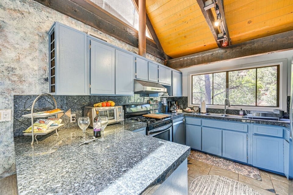 Kitchen | Gas Stove & Granite Countertops | Blue Cabinets & Forest Views