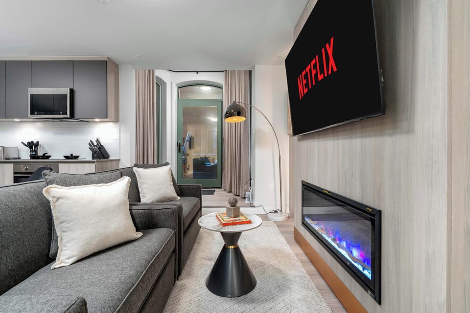 Open-concept living and dining area with Smart TV, fireplace, and modern kitchen