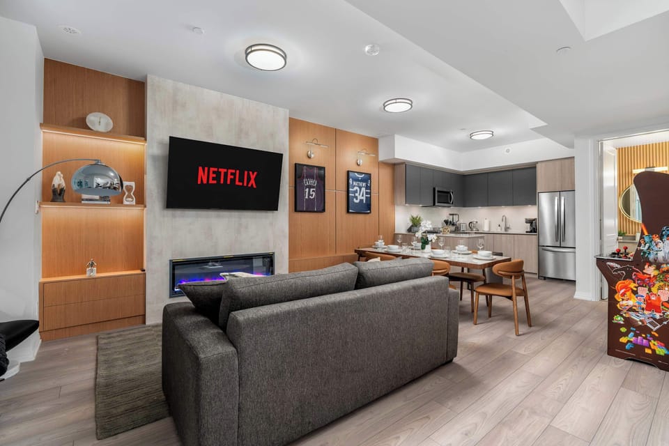 Open-concept living and dining area with Smart TV, fireplace, and modern kitchen.