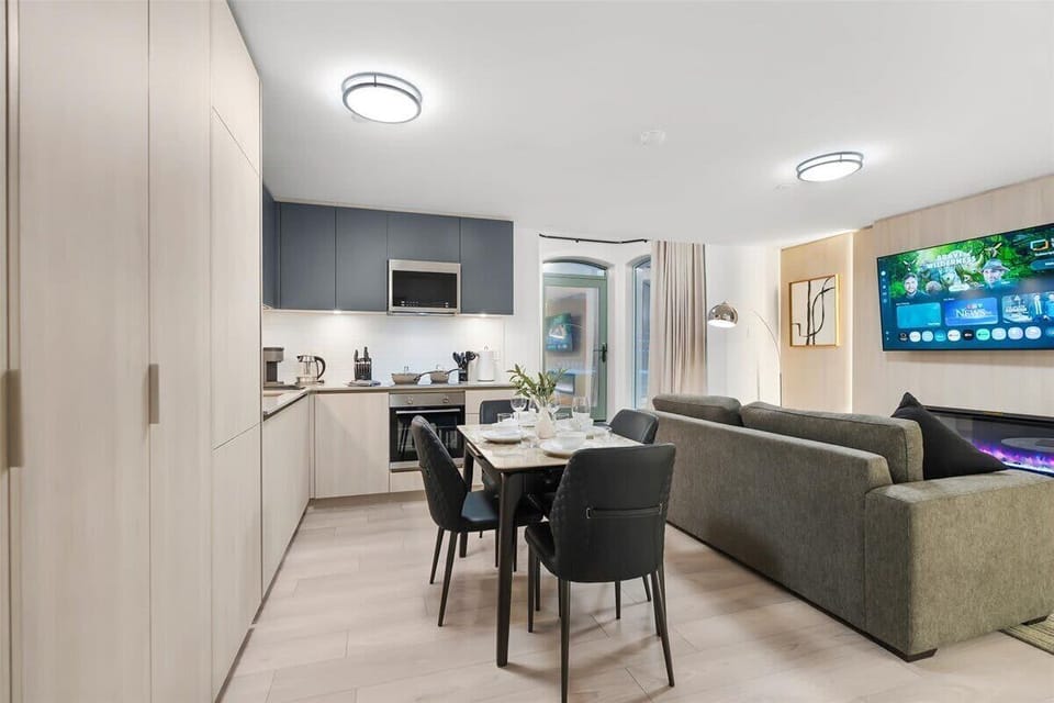 Open-concept living and dining area with Smart TV, fireplace, and modern kitchen