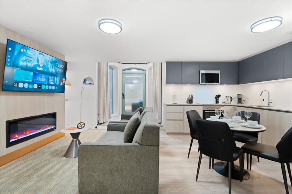 Open-concept living and dining area with Smart TV, fireplace, and modern kitchen