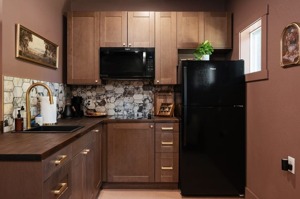 🍳 A sleek kitchen corner fully equipped with a microwave, fridge, and stylish coffee station.