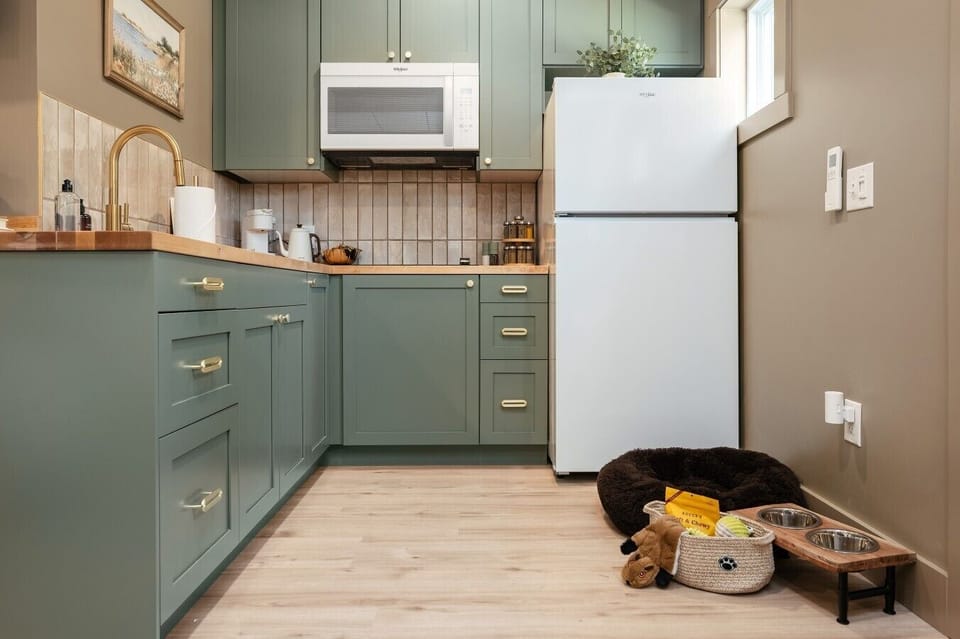 🍽️ Modern sage cabinetry and elegant gold hardware combine function and high-end design.