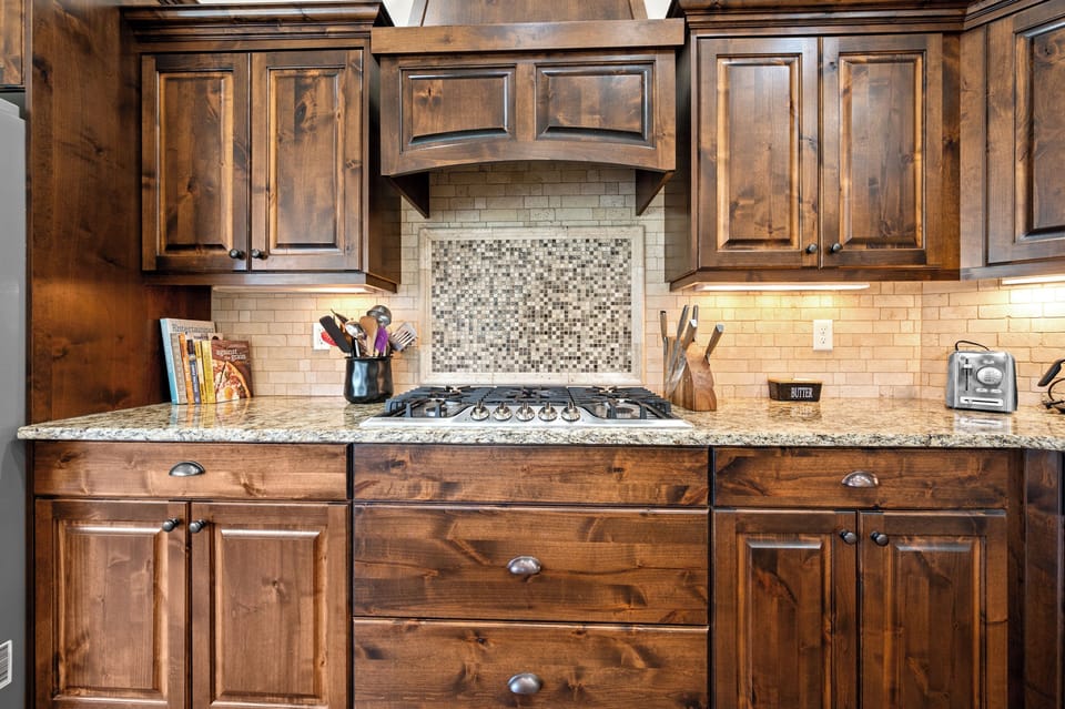 Cook Like a Pro – Featuring a professional gas cooktop, custom range hood, granite countertops, and rich wood cabinetry, this kitchen is designed for everything from quick breakfasts to holiday feasts.