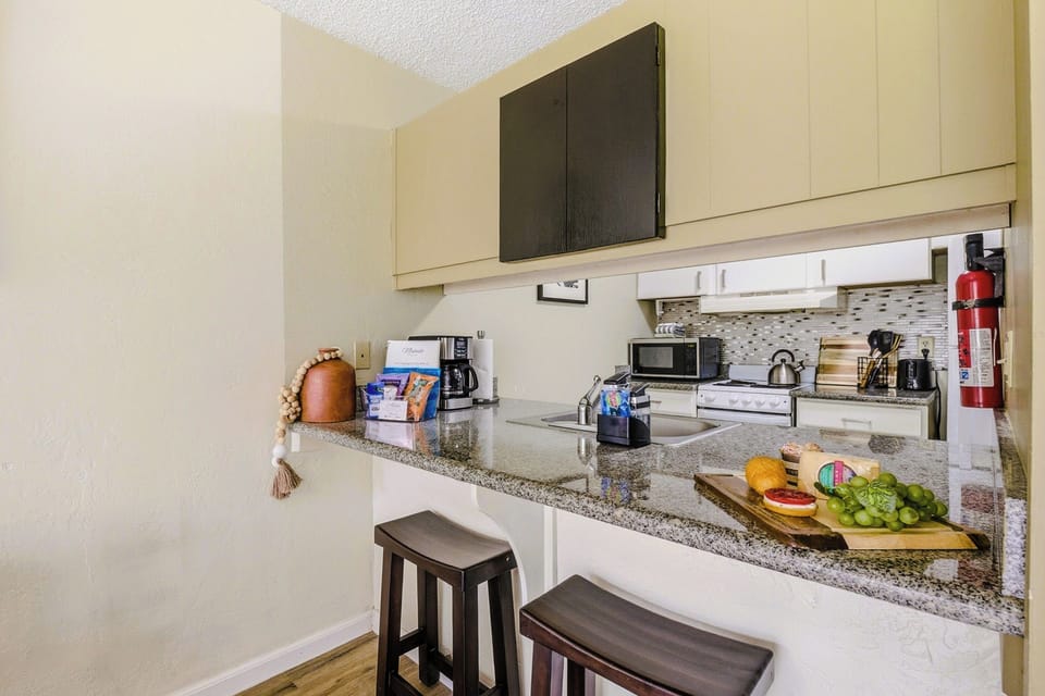 Granite breakfast bar set with a fresh charcuterie spread — pull up a stool and pour the first cup.