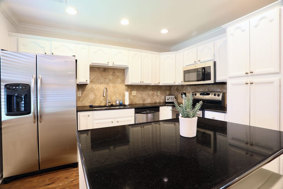 Bright gourmet kitchen with granite island and stainless appliances