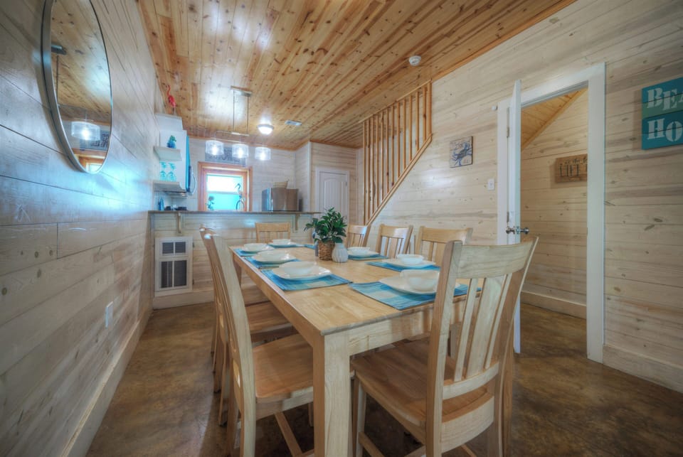 Coastal-inspired dining area with bistro-style charm and a bright kitchen nearby.