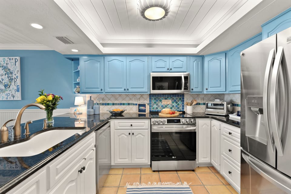 Modern U-shaped kitchen fully equipped with premium stainless steel appliances and a tray ceiling.