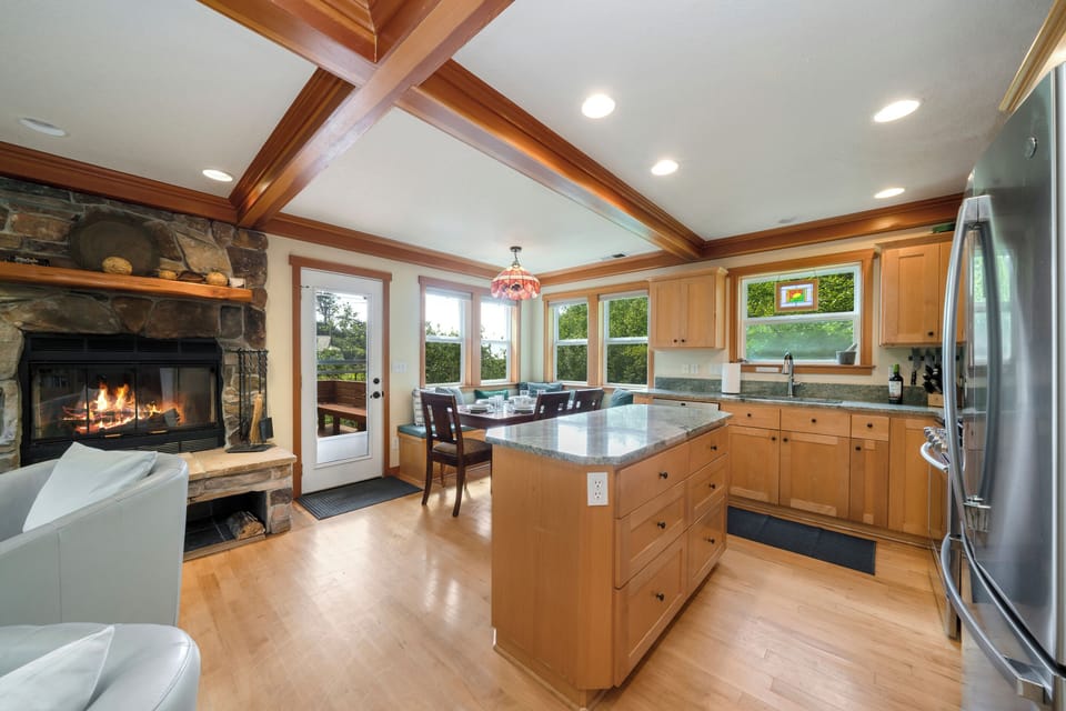 Open dining and kitchen area with access to back deck with hot tub.