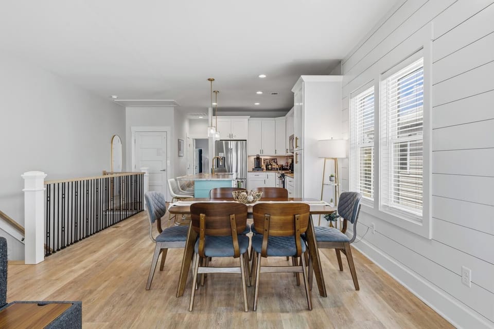 Gather around this beautiful dining table for morning coffee or evening meals with your loved ones. Natural light pours in through plantation shutters, while the open layout connects you to the kitchen and living spaces.
