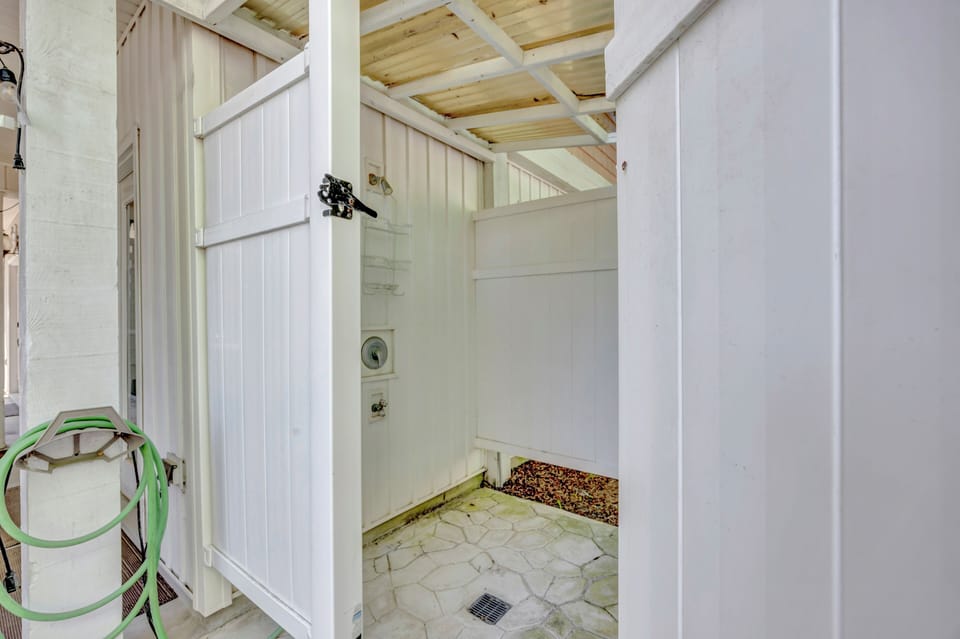 Your private outdoor shower features an open-air design with rustic wood ceilings, perfect for rinsing off after beach or pool time.