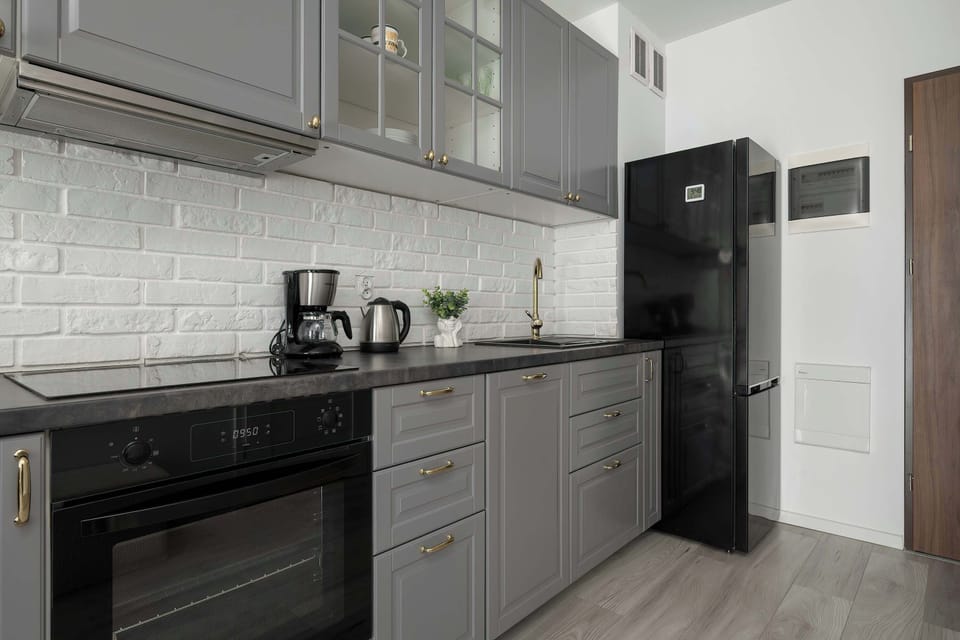 Modern kitchenette with elegant grey cabinets and built-in appliances.