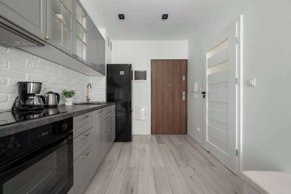 Modern kitchenette with elegant grey cabinets and built-in appliances.