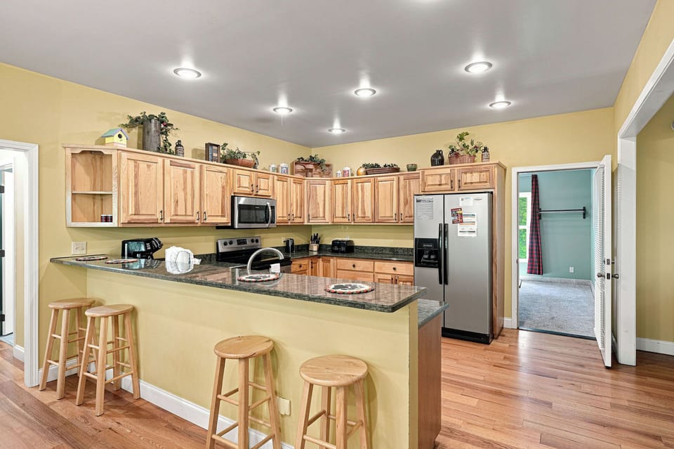 Your fully-equipped kitchen features rich oak cabinetry, granite countertops, and a breakfast bar perfect for morning coffee or casual meals with loved ones.