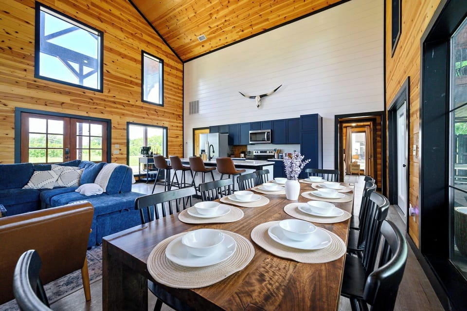 Dining table seats 8 + island bar seats 4 — breakfast before the river, dinner after the fire pit. Seats all 12 guests comfortably.