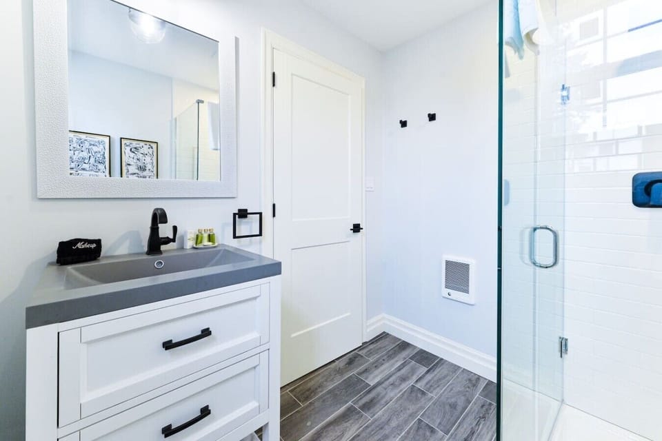 Refresh and recharge in the modern bathroom, featuring a walk-in shower, plush towels, and complimentary amenities for a comfortable stay.