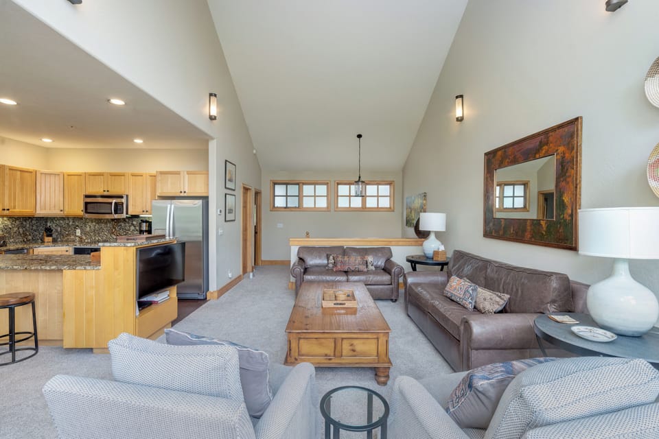 Settle into this spacious living area where vaulted ceilings and natural light create an airy retreat. Your fully equipped kitchen flows into the cozy lounge, perfect for unwinding after a day of adventure.