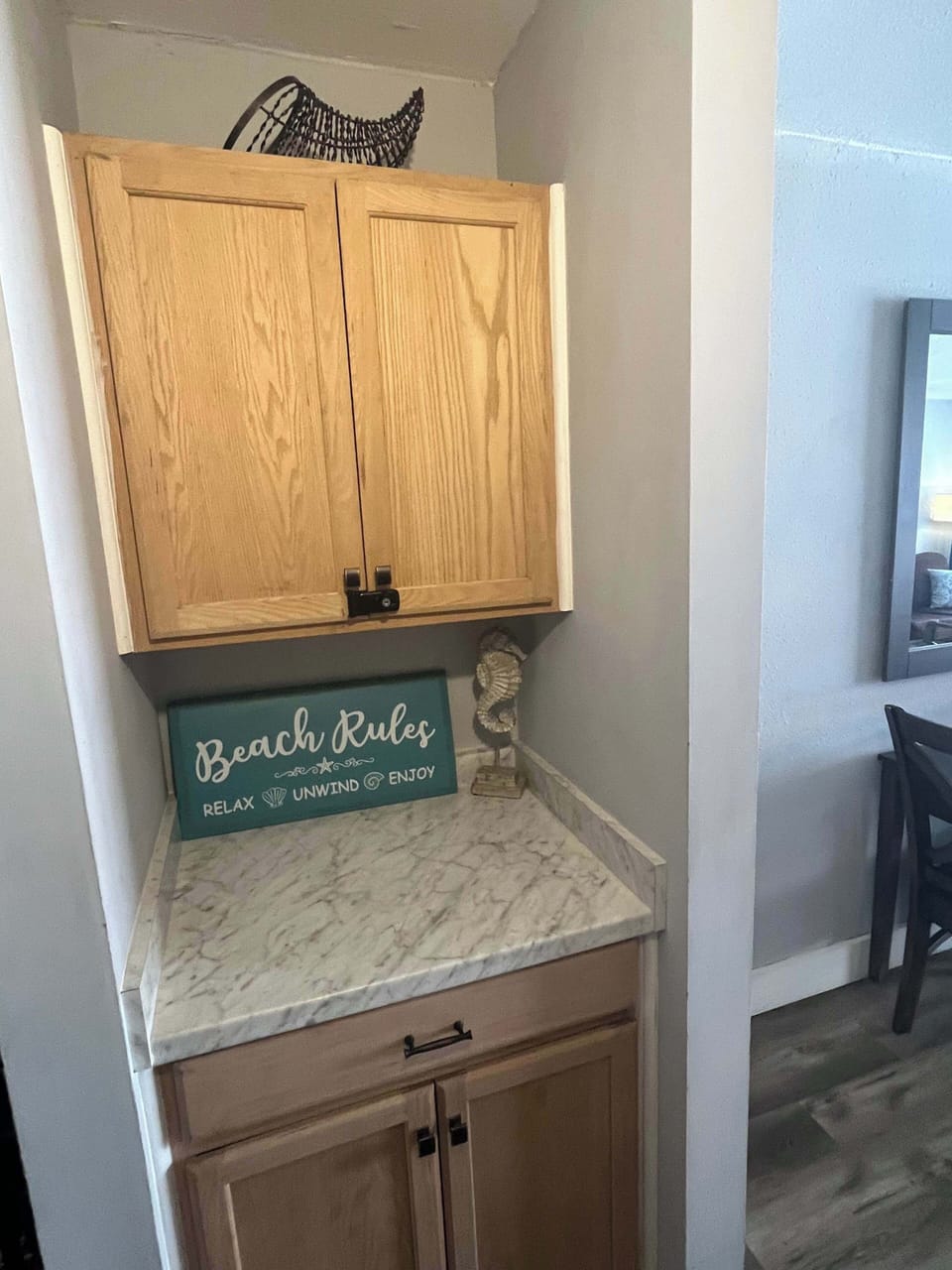 Small storage nook featuring light wood cabinetry, a laminate countertop