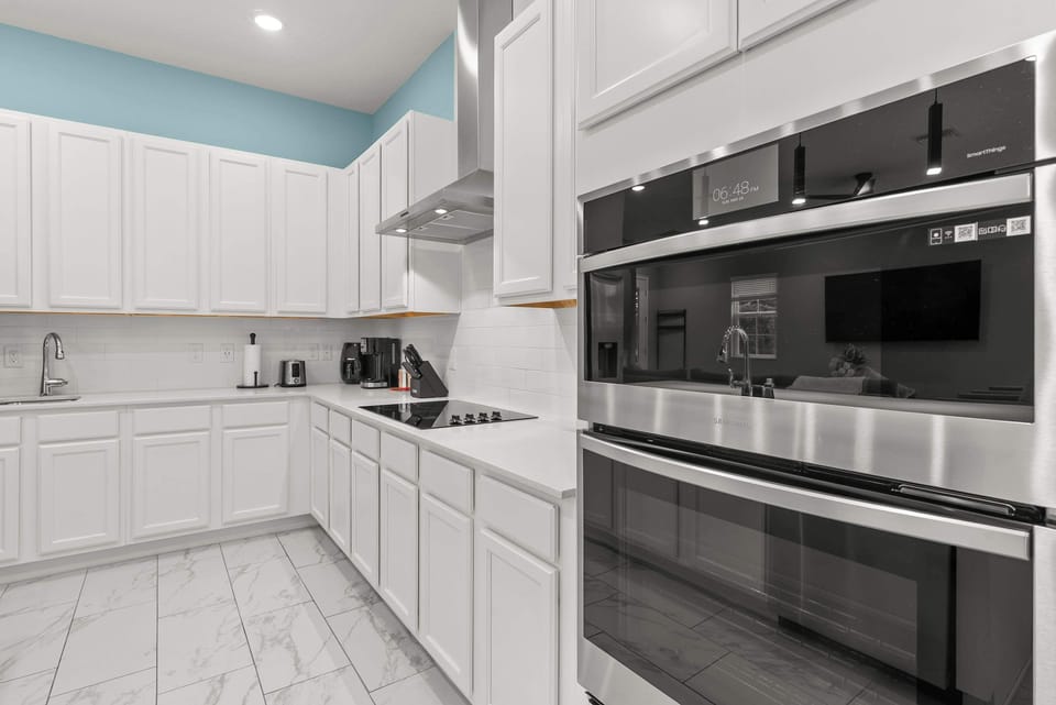 Modern kitchen with white cabinetry and stainless steel appliances