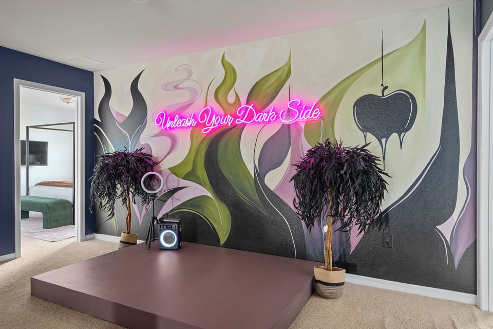 Villain lounge wall with neon sign, dramatic mural, feather decor, and console t