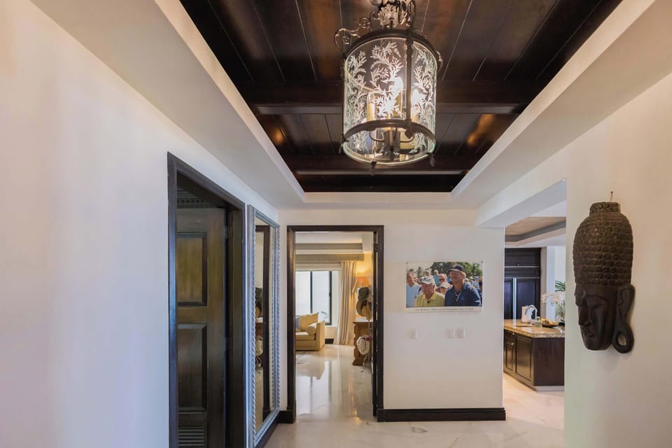 Elegant hallway with decorative ceiling details, stylish lighting, and sophisticated artwork accents.