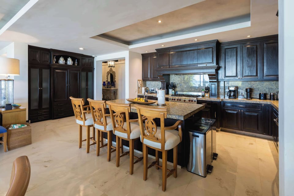 Spacious gourmet kitchen with dark wood cabinetry, bar seating, and an open layout perfect for entertaining.
