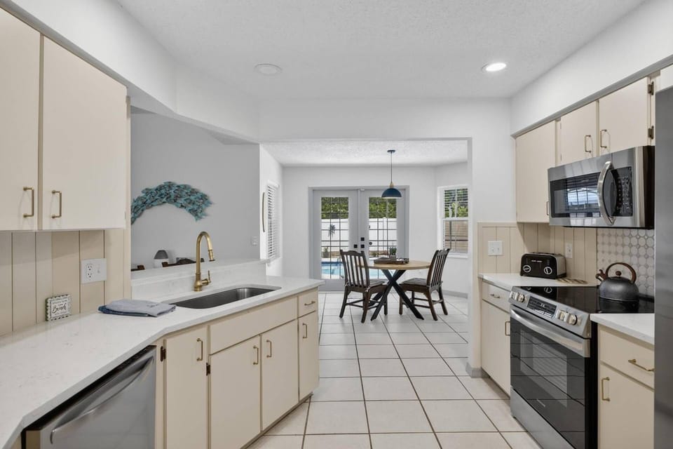 Well-equipped kitchen with everything you need for home-cooked meals, featuring an open concept layout and relaxing views of the pool.