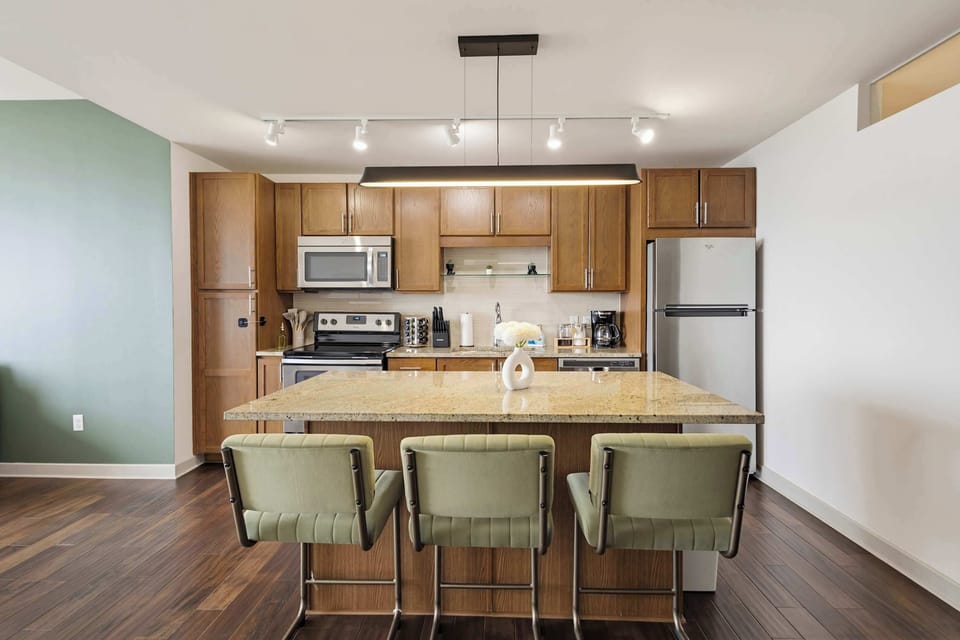 Kitchen and dining area with bar seating, pendant lighting, and stainless appliances